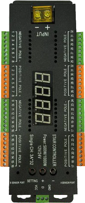 A long black stair-controller board with a four-digit display in the centre and rows of orange and green screw terminals down both edges