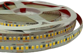 A reel of 24V LED tape on a white spool, three coils of warm-white chips fanned out in front of it