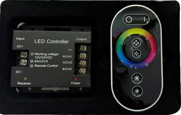 A black LED controller unit paired with a circular touch-wheel remote showing a colour ring